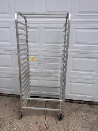 Aluminum cooling rack with multiple shelves, on wheels. Appears in fair condition. Yellow tag labeled 141 is visible.