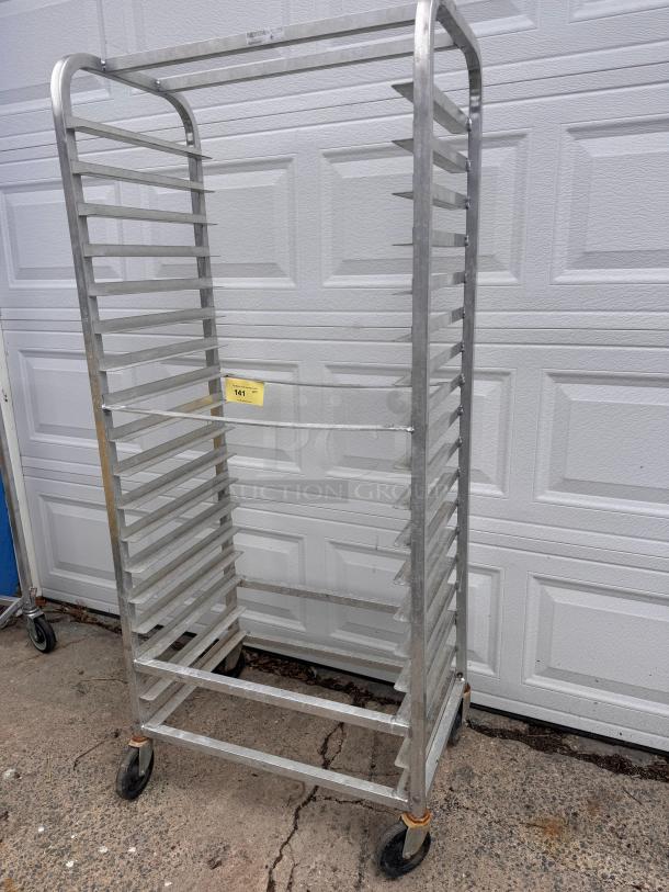 Aluminum cooling rack with multiple shelves, on wheels for easy mobility. Slight rust on wheel areas, otherwise in good condition. Auction tag 141 attached.