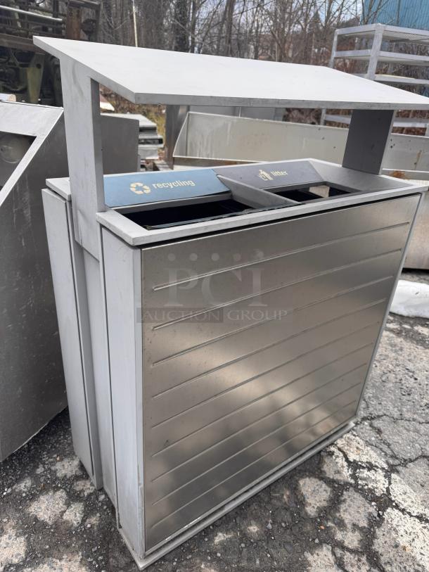 Stainless steel recycling receptacle with hinged lid, dual openings labeled "Recycling" and "Waste," in good condition.