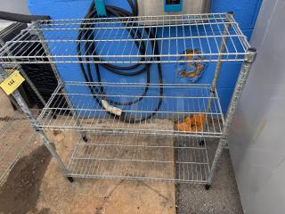 36" metal wire shelf with three tiers and adjustable feet, used condition. Auction tag 144 attached.