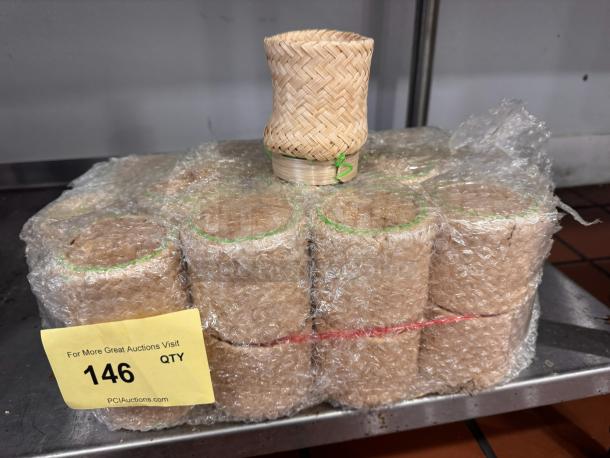 Pack of bubble-wrapped bamboo baskets, small woven design, labeled "146 QTY" for auction, in excellent condition.
