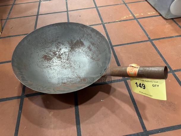 Rustic fry pan/wok with a metal handle, visible wear and patina, auction label 149 attached to handle.