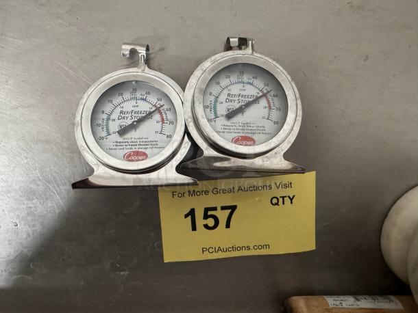 Pair of Cooper refrigerator thermometers with stainless steel frames, dial display, labeled "Refrigerator/Freezer Dry Storage."