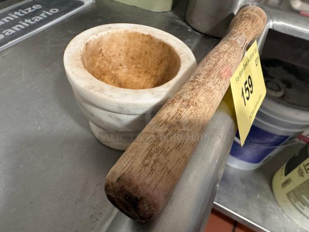 Marble mortar with visible wear and wooden pestle, auction lot 159 tag. Ideal for grinding and mixing.