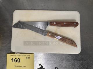 Cutting board with two bar knives featuring wooden handles. One knife marked with "KIWI" sticker. Used condition.