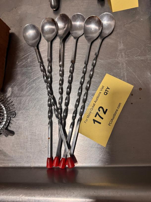 Set of six twisted bar spoons with red plastic tips, item BIDX6. Minor wear visible. Lot number 172.