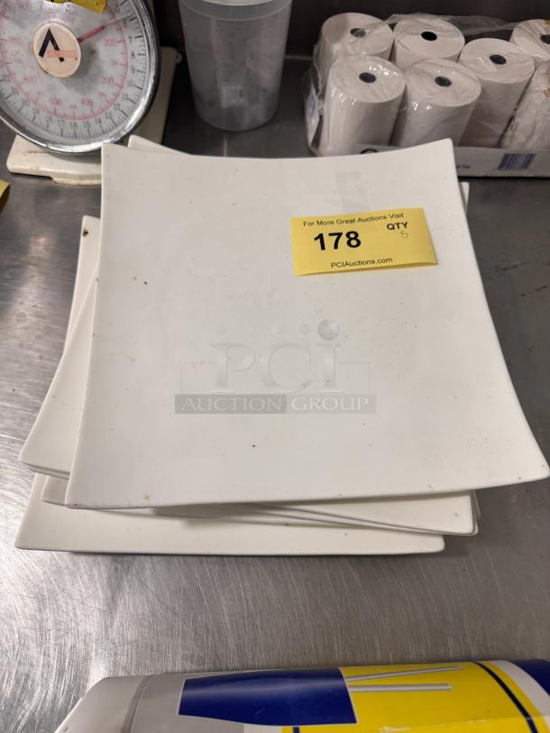 Square plate BIDX5 set, white, gently used with minor marks. Yellow auction tag labeled "178 QTY 5."