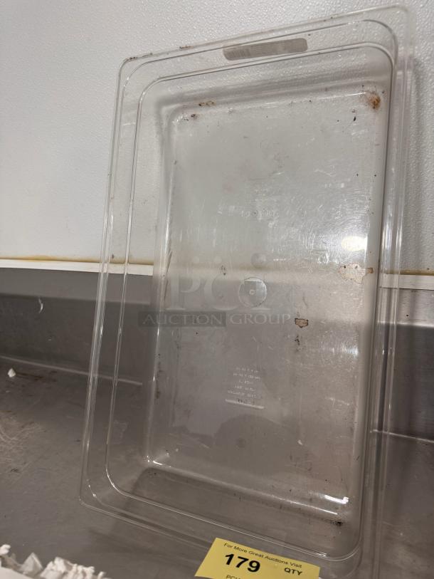Clear 4-inch food container, 1/1 size, with visible surface marks and residue. Markings indicate storage measurements.