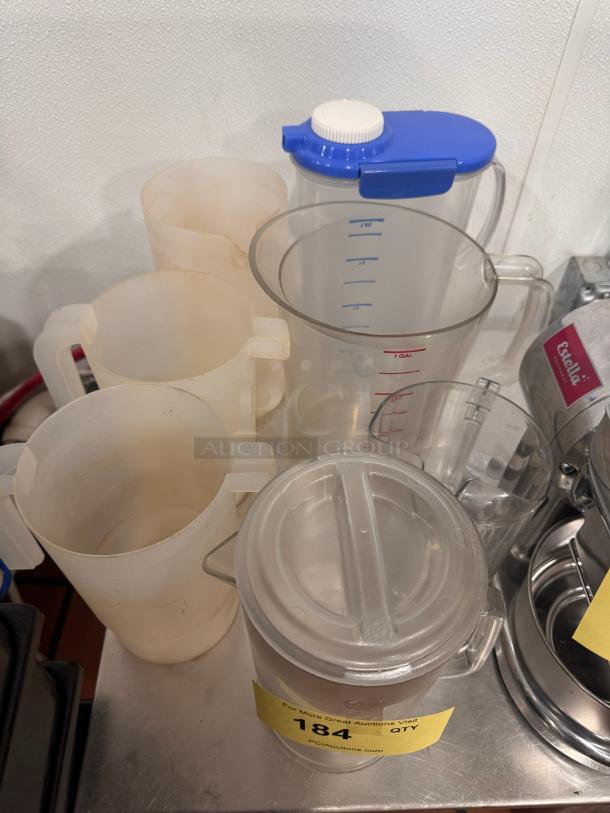Lot of miscellaneous pitchers, including plastic and glass types, various sizes and conditions, with auction tag labeled "184".