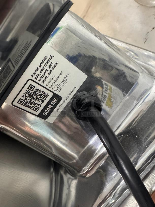 Estella electric hard cheese grater, model JDECB051-12, 120V, 1/2 HP. Label with QR code for product info visible.