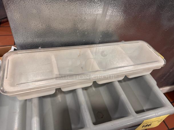 Clear plastic condiment tray with four compartments, hinged lid, slight wear. Ideal for organizing condiments.