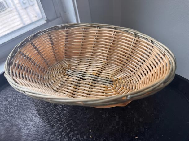 Wicker food basket with a natural finish, showcasing an oval shape and woven design. In good condition, no visible labels.