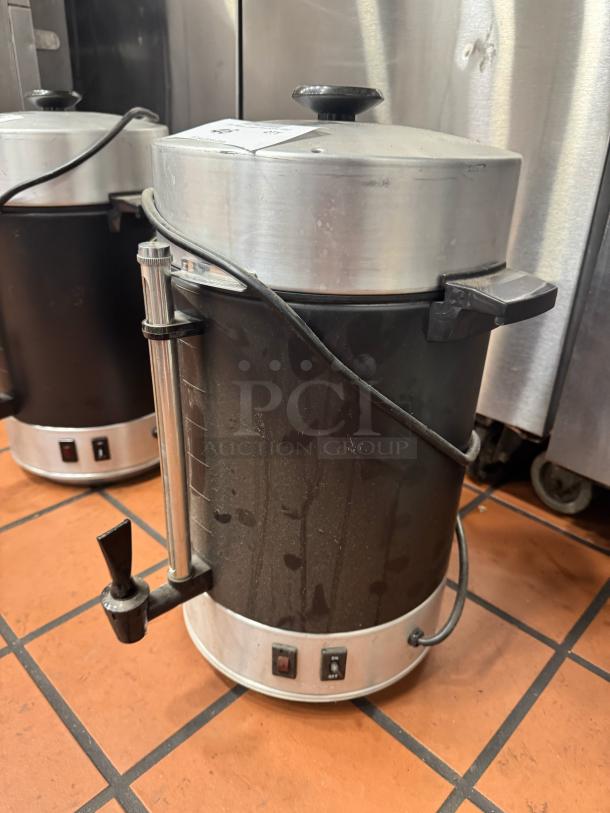 Stainless steel coffee urn/percolator BIDX2, with spigot and power controls; shows signs of use and wear.