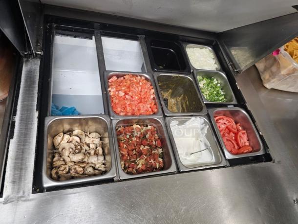 TRUE 60" prep-table with various food pans containing mushrooms, tomatoes, onions, and more. Stainless steel, tested & working.