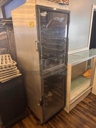METRO DD8119 holding cabinet with clear doors, multiple shelves, on casters. Metal exterior, visible latch, used condition.