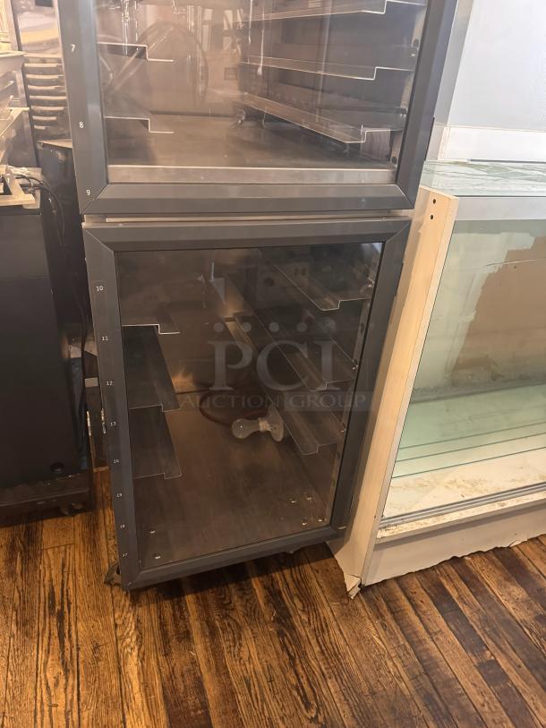 METRO DD8119 holding cabinet, metal frame with clear doors, multiple shelves, good condition, numbered shelf guides.