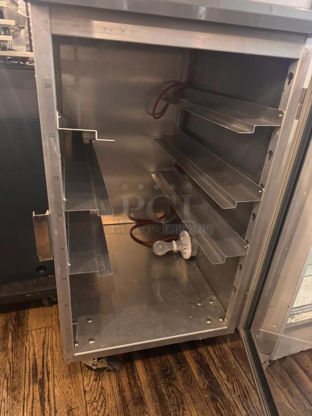 METRO DD8119 holding cabinet, stainless steel, multiple shelves, door open. Suitable for food service, visible wear.