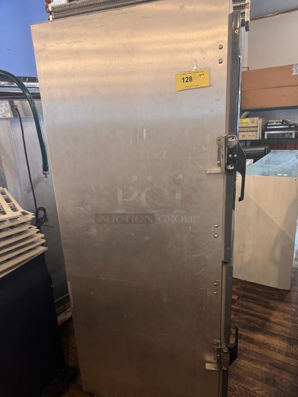 METRO DD8119 holding cabinet, silver finish, upright design, visible wear. Yellow tag: auction lot 128.