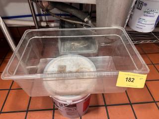 Clear plastic food storage container, 1/1 x 8in size, used condition. Auction lot tag marked "182" visible.