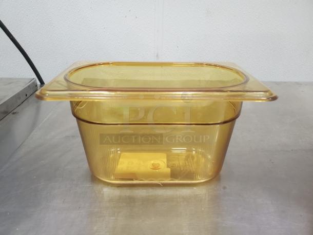 1/9 size, 4-inch amber plastic food pan, model BIDX6. Slightly used condition with visible ribbed design and transparent lid.