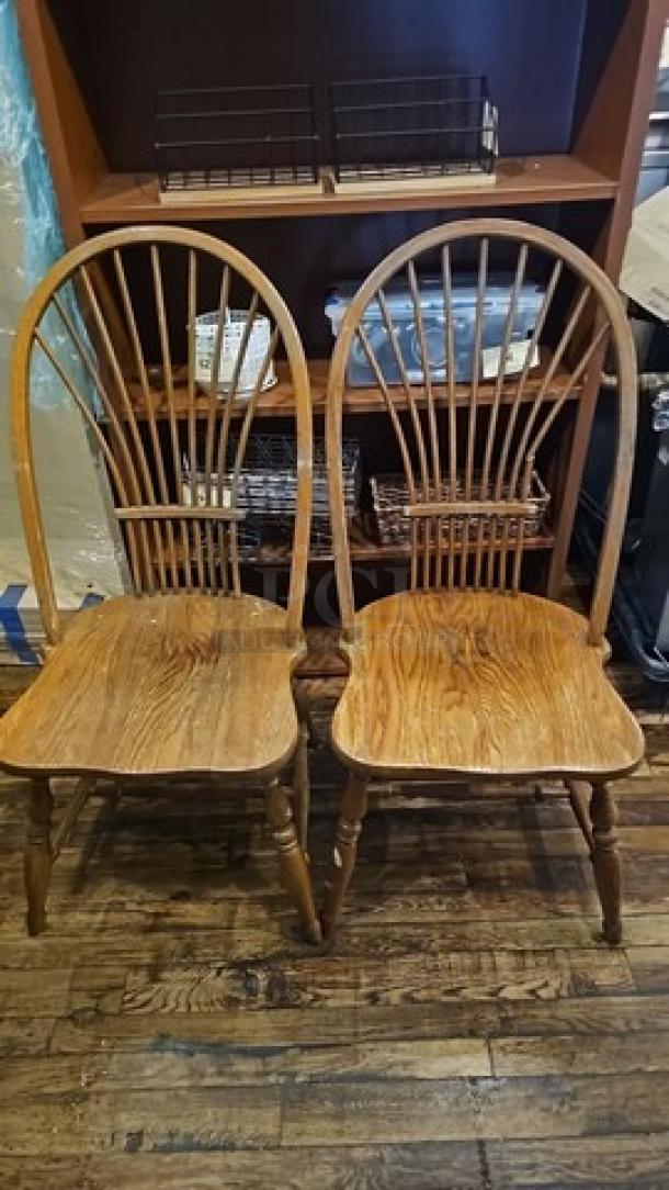 Two Wooden Chair BIDX2 with spindle back design, natural finish, slight wear. Ideal for rustic or vintage decor.