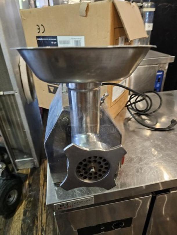 Stainless steel Meat Grinder MG-IT-0022-C 115V, used condition, features grinding plate and feed tray. Power cord attached.