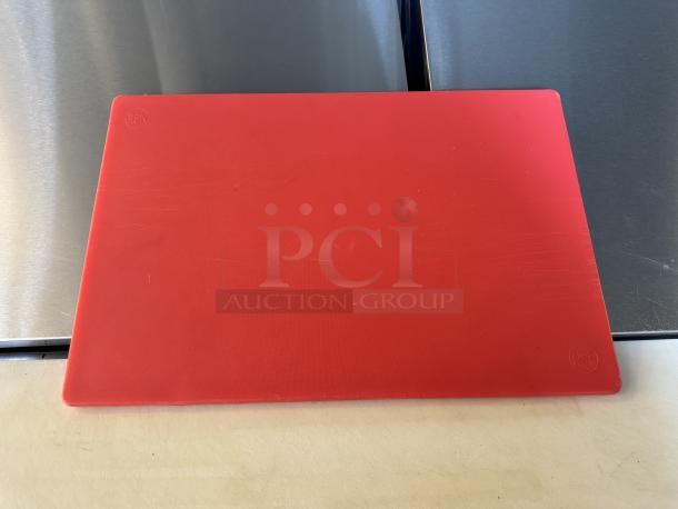 Red cutting board with minor surface scratches, NSF logo in corners, rectangular, durable plastic material.