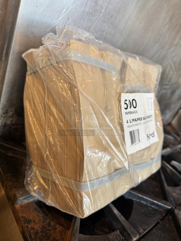 Pack of 500 kraft paper bags wrapped in plastic. Label specifies quantity and type. New, unused condition.