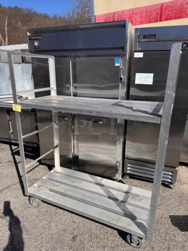 Heavy-duty aluminum shelving unit, two-tier, with wheels. Good condition, suitable for industrial use.