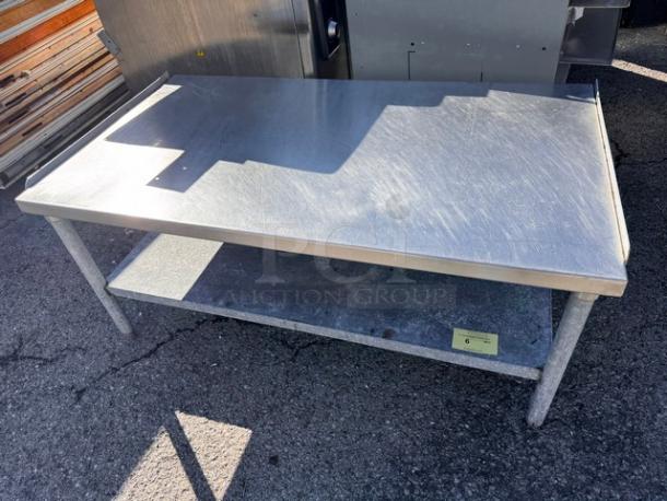 53 1/2" stainless steel stand with lower shelf, used condition, scratch patterns on surface, ideal for commercial kitchens.