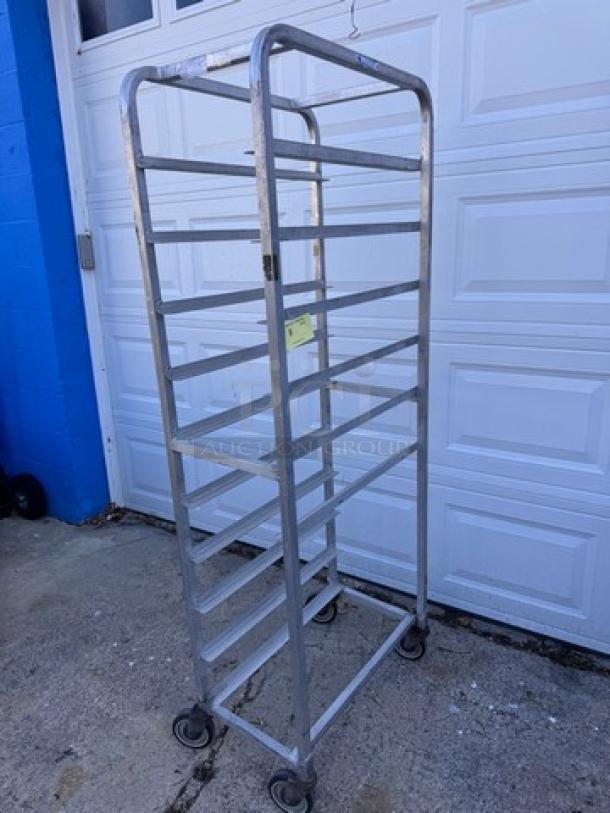 Aluminum pan rack with 10 slots, on casters. Used condition, suitable for bakery or kitchen storage.