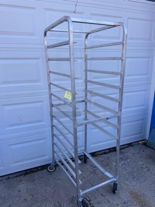 Aluminum pan rack with multiple shelves, rolling wheels; appears in good condition, suitable for commercial kitchen use.