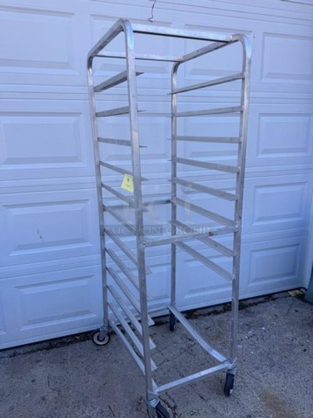 Aluminum pan rack with multiple shelves, on wheels, in good condition. Ideal for commercial kitchen use.