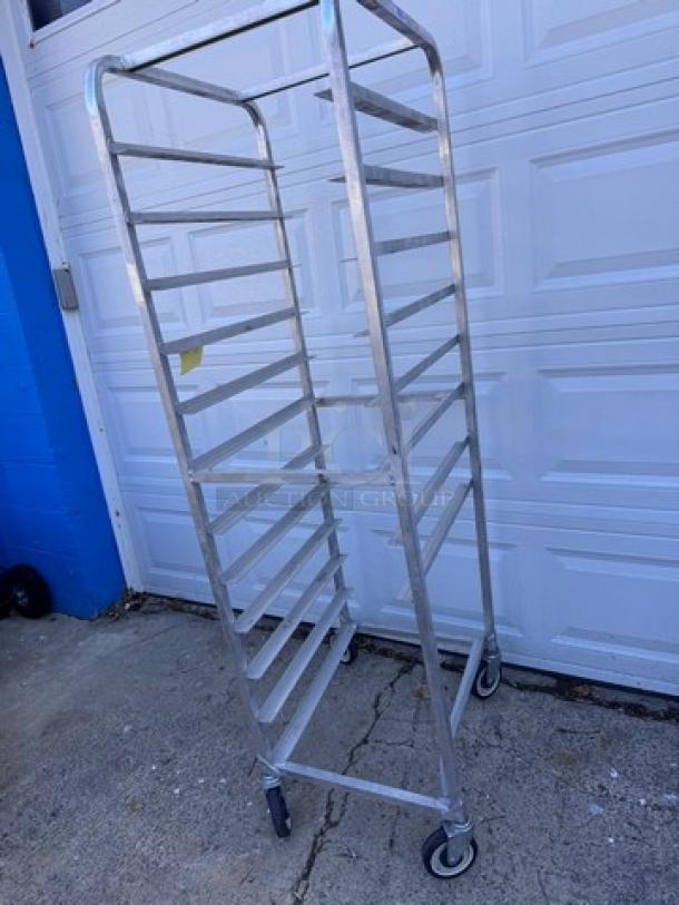 Aluminum pan rack with multiple shelves, sturdy casters, good condition. Ideal for commercial kitchens or bakeries.