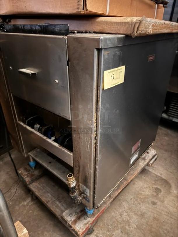 Commercial-grade stainless steel cooking equipment labeled "Burger IM," showing wear, with control knobs and service panel.