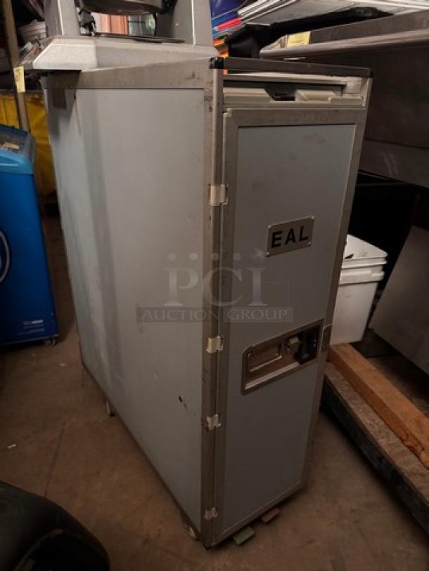 EAL airline service cart, metal, vintage, with locking mechanism, visible wear. EAL logo plaque on front door.