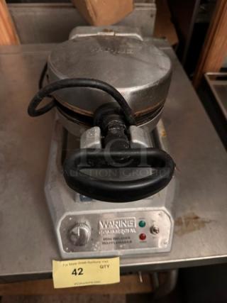 WARING Mini Belgian Waffle Maker, stainless steel, commercial-grade, visible wear, model identifier on label, functional knobs.
