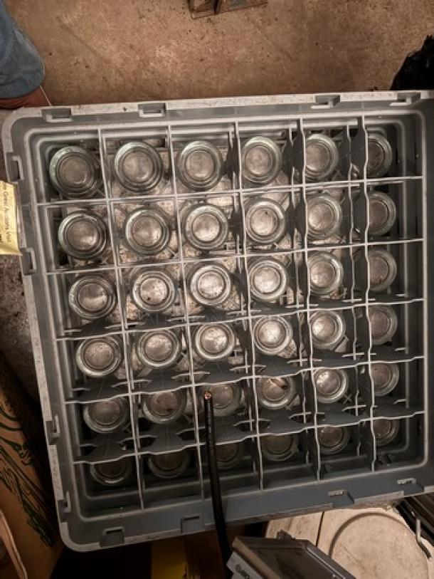 Rack filled with glassware, organized in a grid. All glasses appear intact. Sold as one lot.