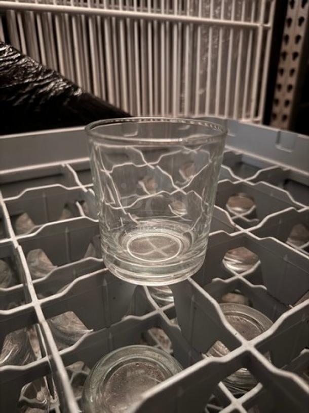 Rack of clear glass tumblers in a dishwasher rack, excellent condition, auctioned as a complete set.