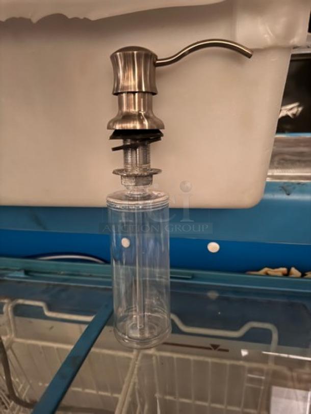 Stainless steel bottle dispenser BIDX5, cylindrical clear body, brushed metallic pump, in excellent condition.