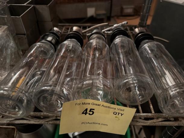 Clear glass bottle dispensers BIDX5, set of five, stainless steel pour spouts, excellent condition, on display rack.