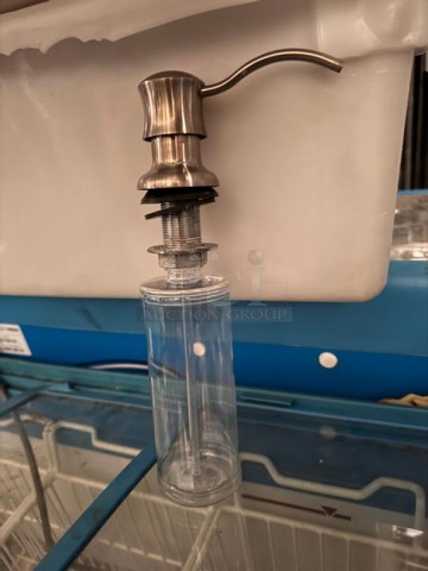 Bottle dispenser BIDX5, stainless steel pump, clear plastic body, unused condition, suitable for liquid soap or lotion.