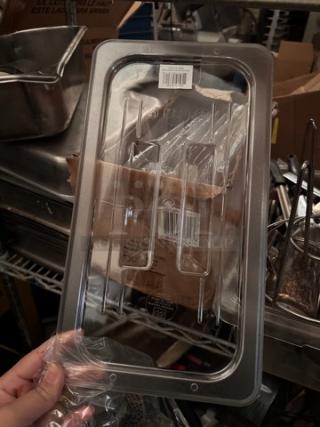 Brand new clear plastic lid for food pan, rectangular shape, with BIDX9 label and barcode, in pristine condition.