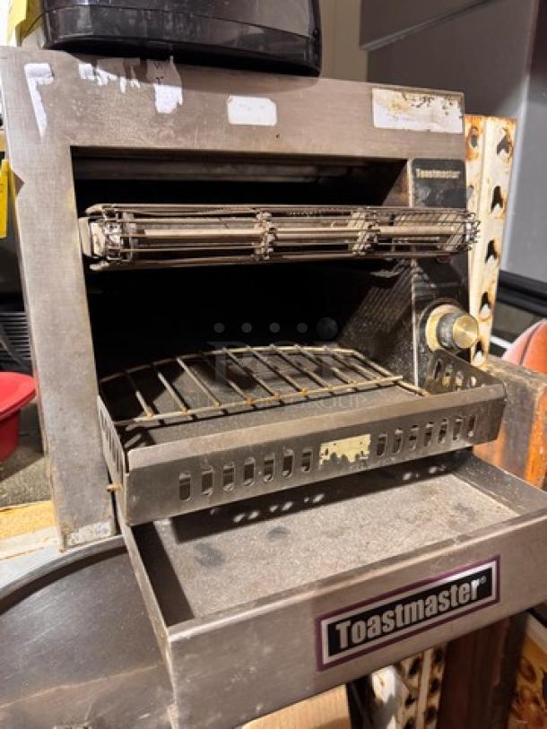 Toastmaster commercial conveyor toaster, stainless steel, showing signs of use, visible controls, and brand label.