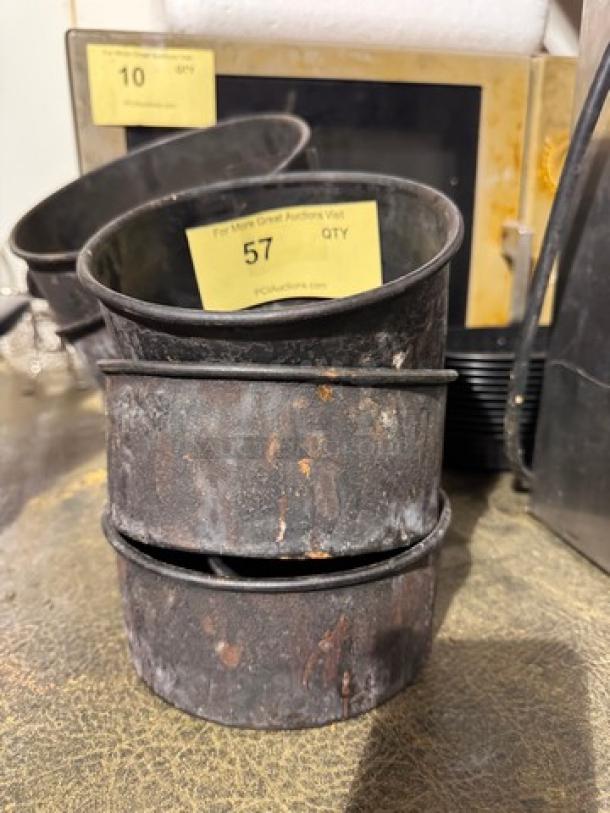 Aged round baking pan set, labeled "57 QTY", showing rust and wear, ideal for vintage kitchen decor or restoration.