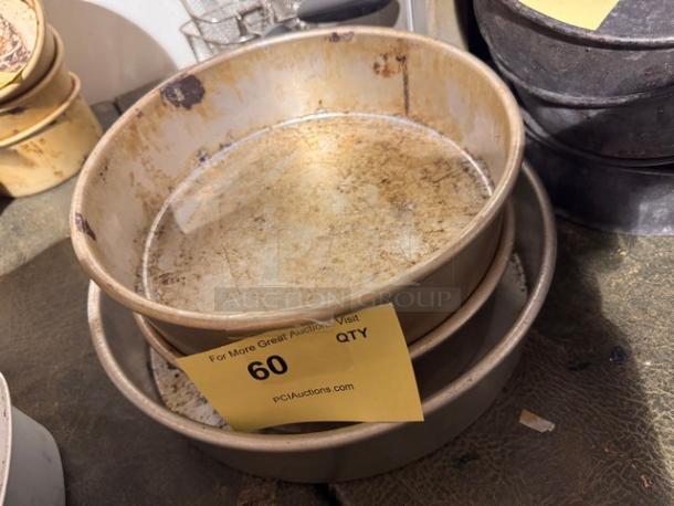 Round metal baking pans, set of three, heavily used with visible wear and patina. Tag indicates "60 QTY" for auction details.