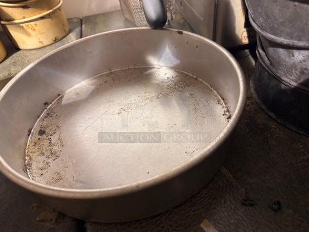 Round metal baking pan BIDX3, visibly used with surface wear, ideal for baking enthusiasts seeking vintage kitchenware.