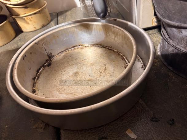Two round baking pans, model BIDX3, nested together. Used condition with visible signs of wear and discoloration.