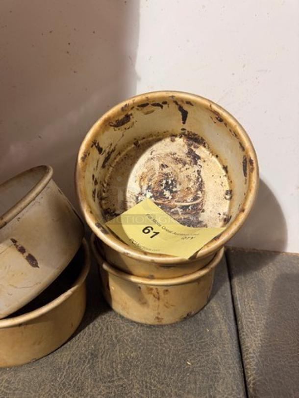 Vintage baking pan BIDX5, well-used condition with visible marks. Circular shape, stacked with similar pans. Auction tag showing number 67.