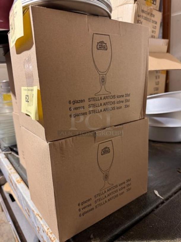 Two boxes of STELLA Artois glasses, each containing six 33cl glasses, labeled in multiple languages.